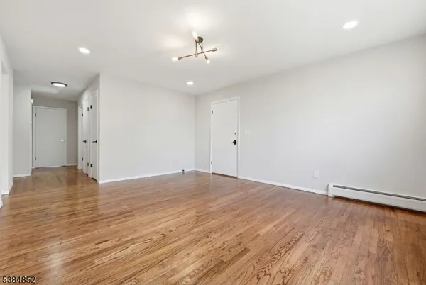 an empty room with wooden floor and ceiling fan