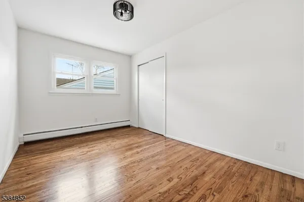 an empty room with wooden floor and window