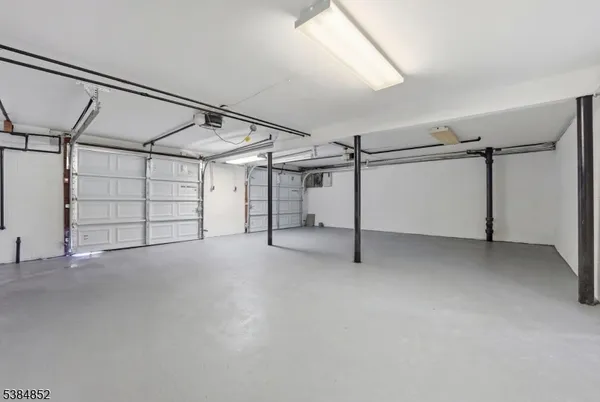 a view of an empty room with wooden floor and white walls