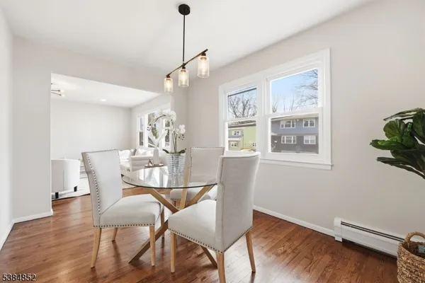 a view of a dining room with furniture a chandelier and wooden floor