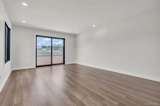 a large kitchen with stainless steel appliances sink a microwave and wooden floor