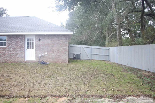 a view of a refrigerator in kitchen and an empty room