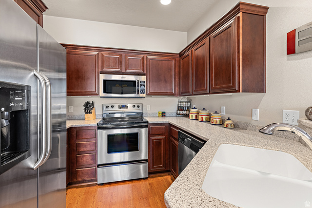 2484 Manzoni Road Santa Clara, UT 84765 - Photo 15 of 27 Kitchen with stainless steel appliances, light stone countertops, and light wood-style flooring
