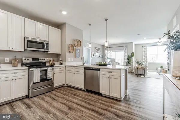 a kitchen with stainless steel appliances granite countertop a refrigerator sink and white cabinets