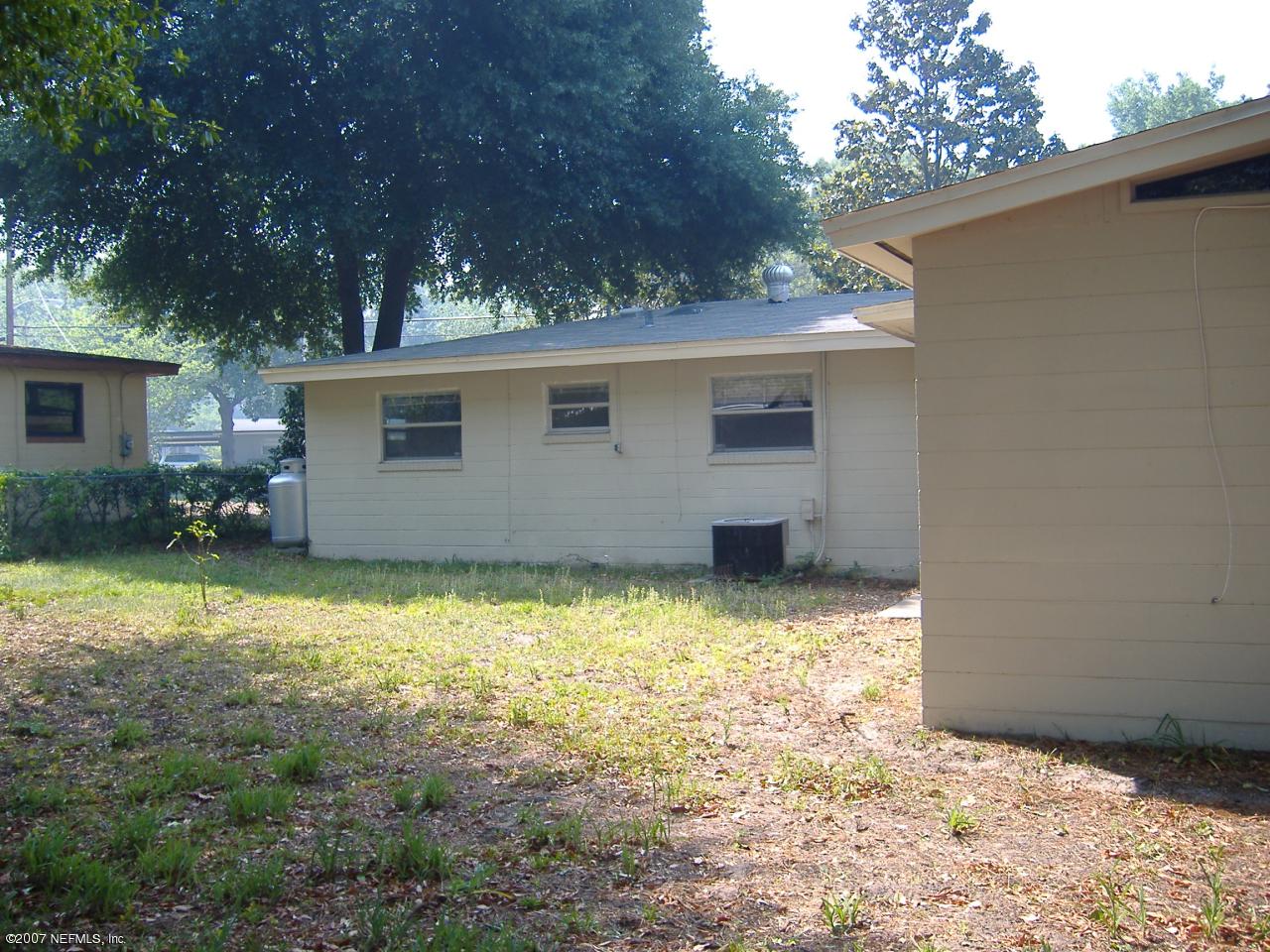 6829 Heidi Road Jacksonville, FL 32277 - Photo 3 of 9 a backyard of a house with yard and garage
