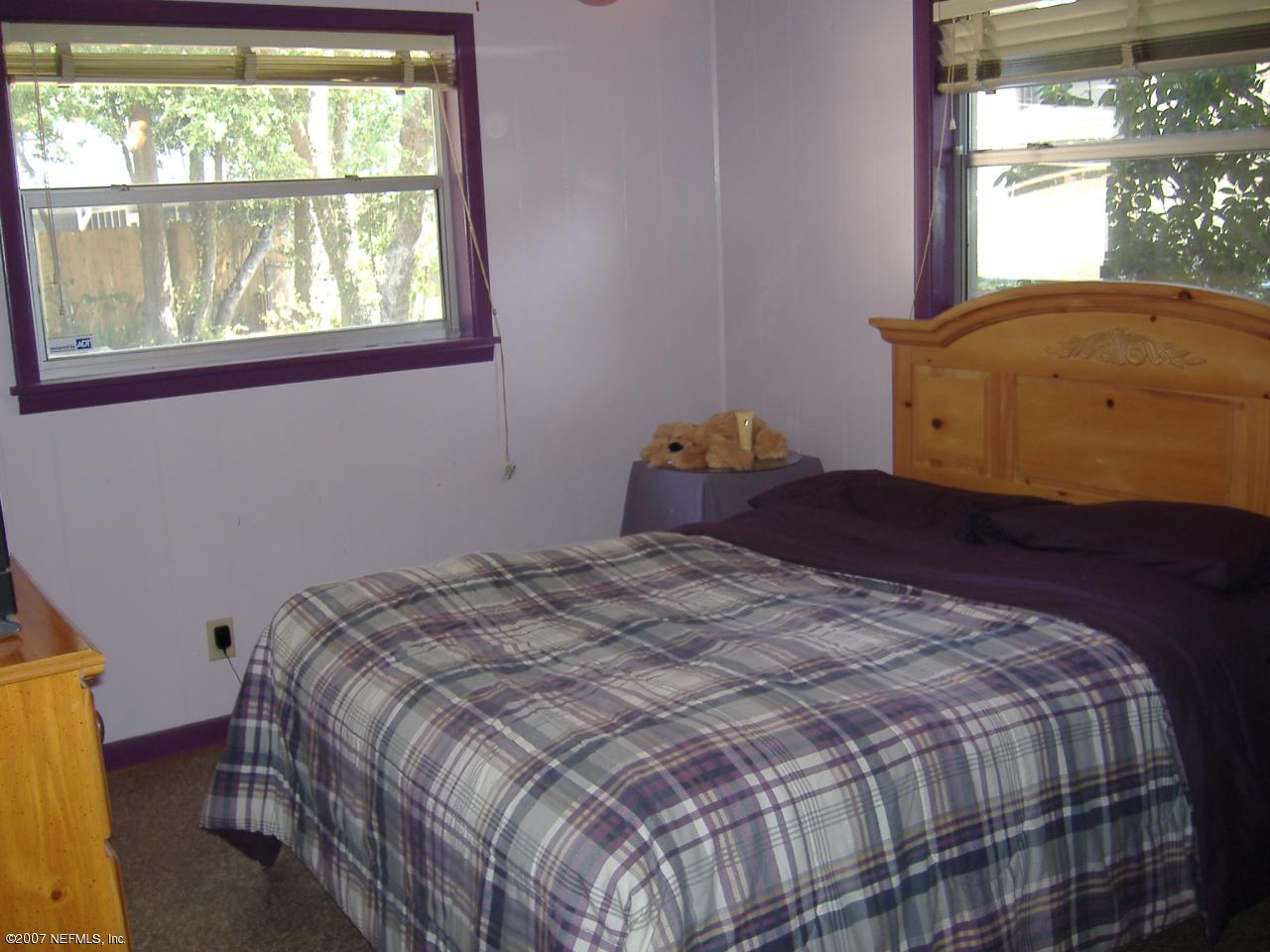 6829 Heidi Road Jacksonville, FL 32277 - Photo 8 of 9 a bed sitting in a bedroom next to a window