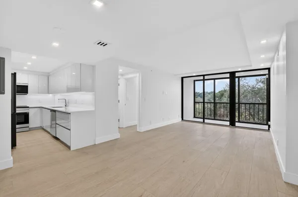 a view of large kitchen with stainless steel appliances kitchen island large windows and cabinets
