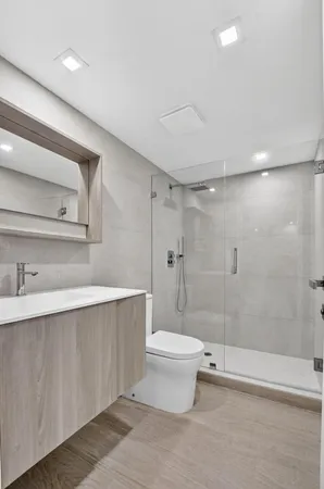 a bathroom with a sink a toilet and shower