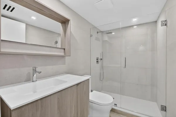 a bathroom with a sink a toilet and shower
