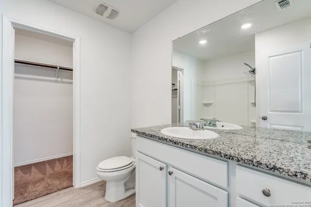 a bathroom with a granite countertop sink toilet and shower