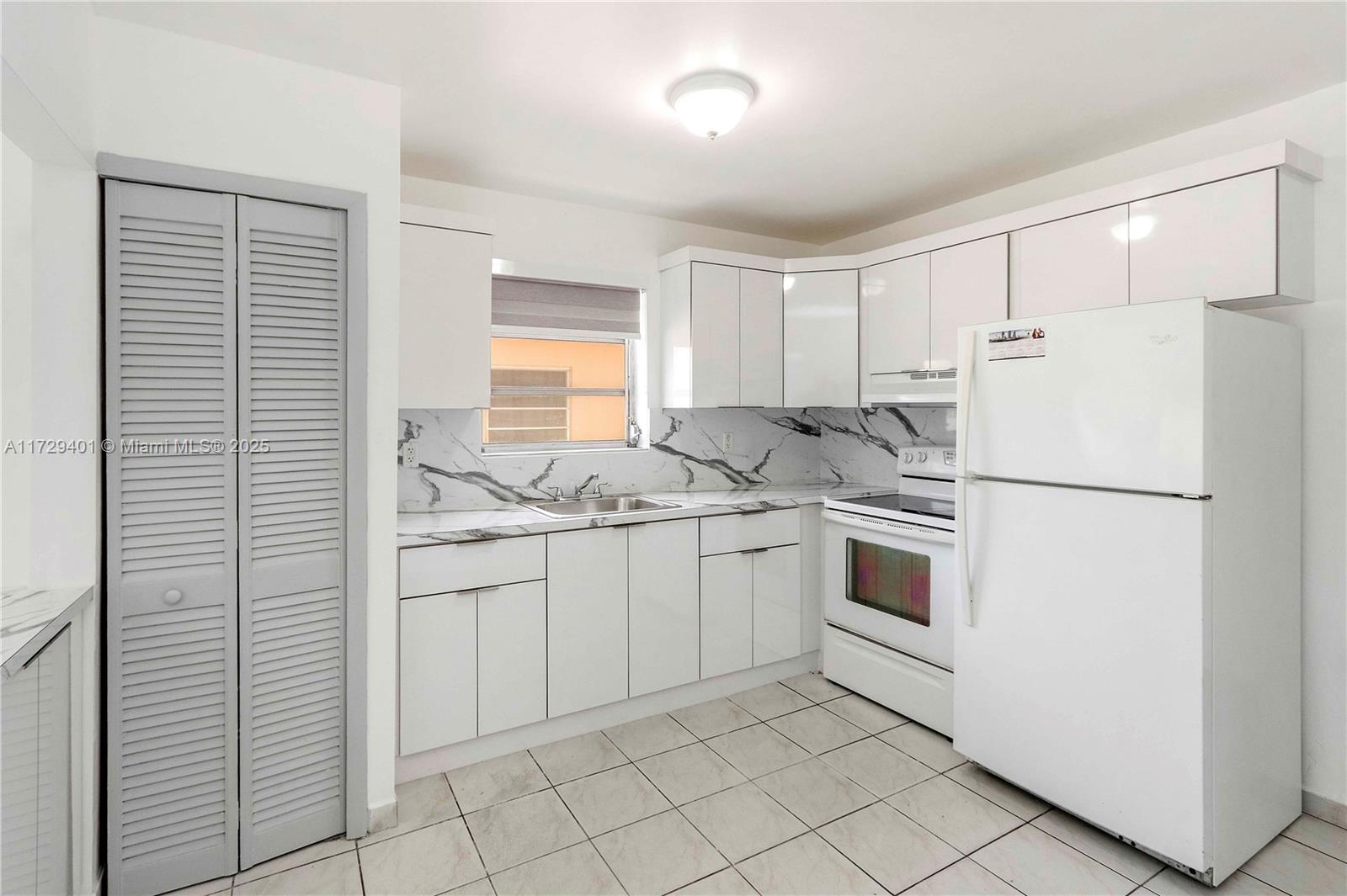 642 East 2nd Avenue, Unit A Hialeah, FL 33010 - Photo 6 of 27 a kitchen with white cabinets and white appliances