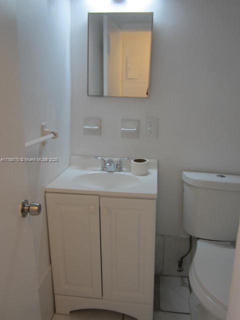 Collier City Pompano Beach, FL 33069 - Photo 36 of 53 a bathroom with a toilet sink vanity and mirror