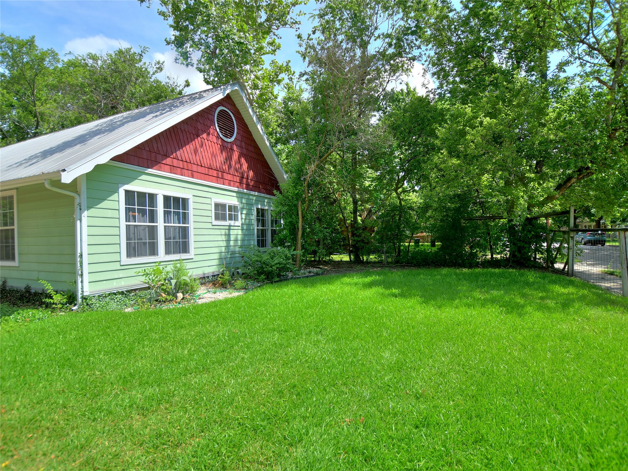 4604 Red River Street, Unit A Austin, TX 78751 - Photo 14 of 15 Vibrant green siding and red shake gable detail complement the metal roof