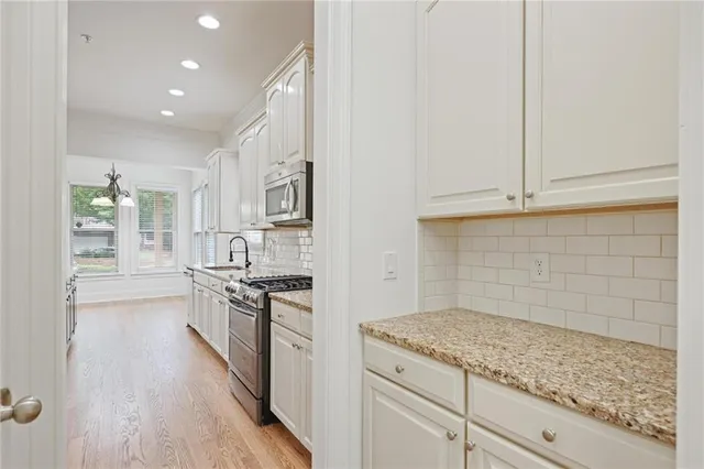 a kitchen with granite countertop white cabinets and appliances