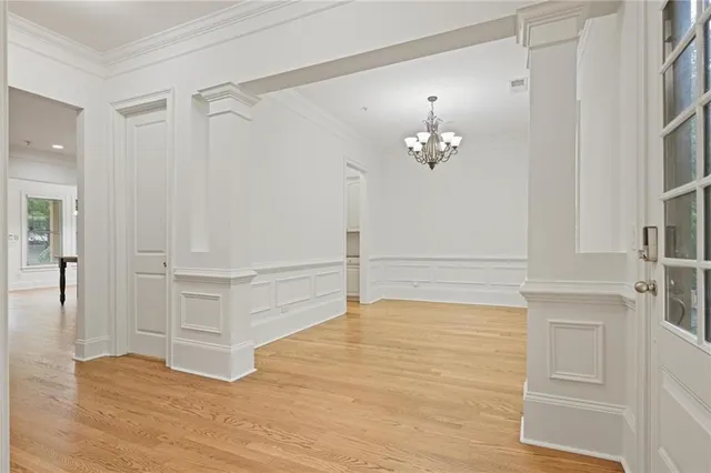 a view of a hallway with closet and chandelier