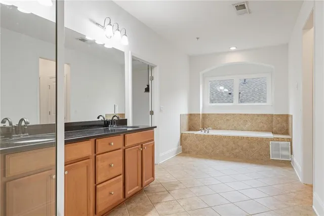a spacious bathroom with a tub sink and mirror