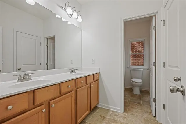 a bathroom with a granite countertop sink a toilet and shower