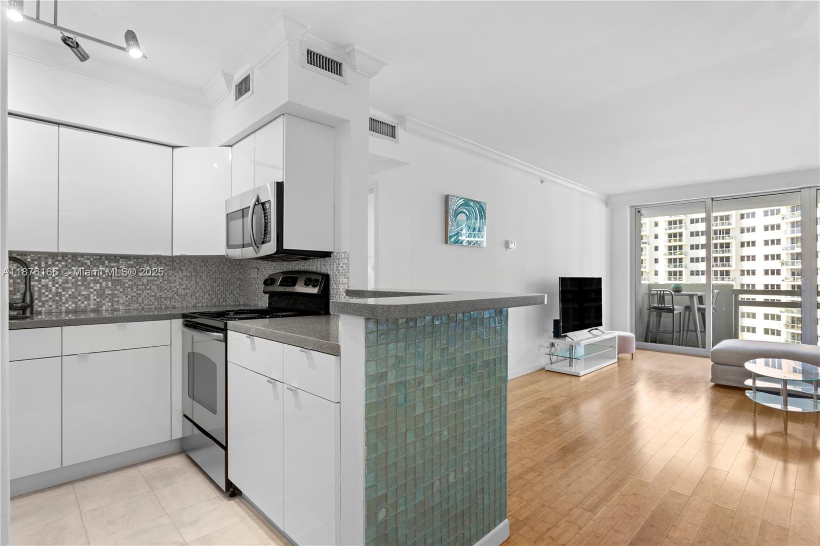 1500 Bay Road, Unit 866S Miami Beach, FL 33139 - Photo 2 of 19 a kitchen with stainless steel appliances granite countertop a stove top oven a sink a counter space and cabinets