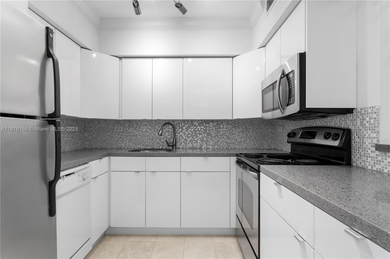 1500 Bay Road, Unit 866S Miami Beach, FL 33139 - Photo 6 of 19 a kitchen with white cabinets and refrigerator