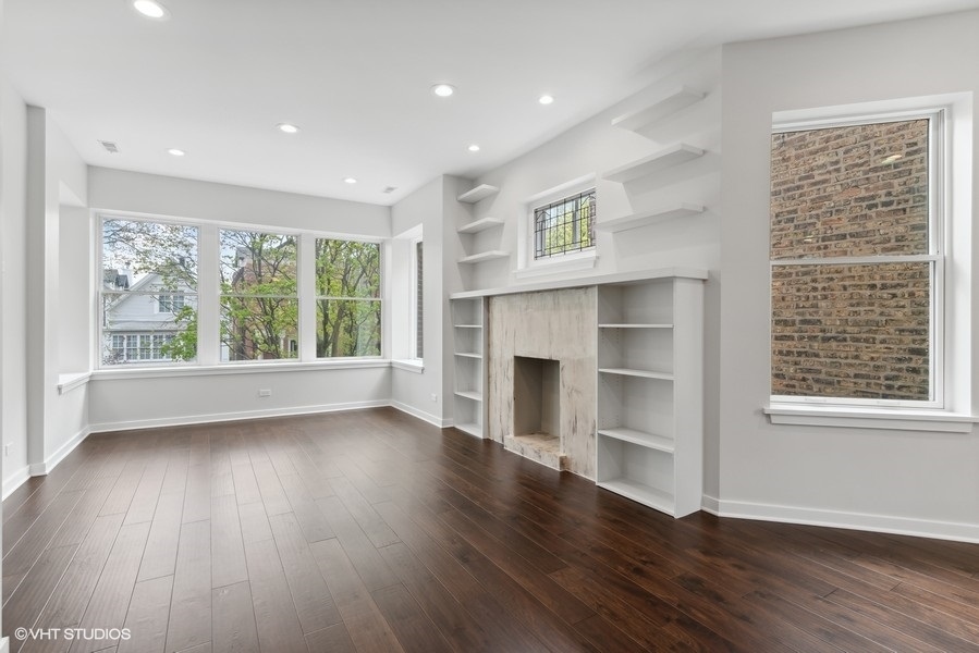 1220 West Roscoe Street Chicago, IL 60657 - Photo 20 of 35 a view of an empty room with wooden floor and a window