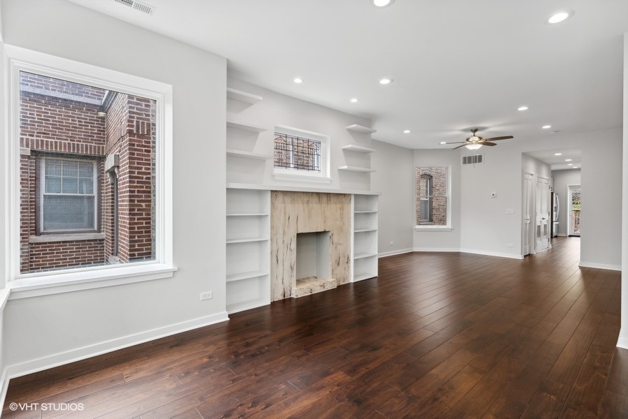 1220 West Roscoe Street Chicago, IL 60657 - Photo 21 of 35 a view of an empty room with wooden floor and a window
