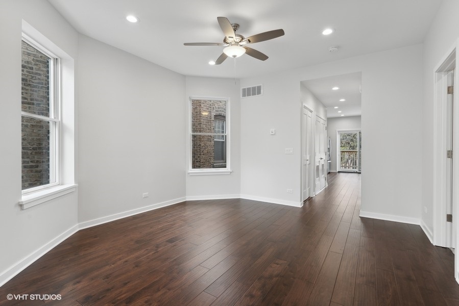 1220 West Roscoe Street Chicago, IL 60657 - Photo 22 of 35 a view of an empty room with a window and wooden floor