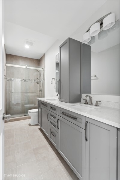 1220 West Roscoe Street Chicago, IL 60657 - Photo 25 of 35 a spacious bathroom with a double vanity sink toilet and shower