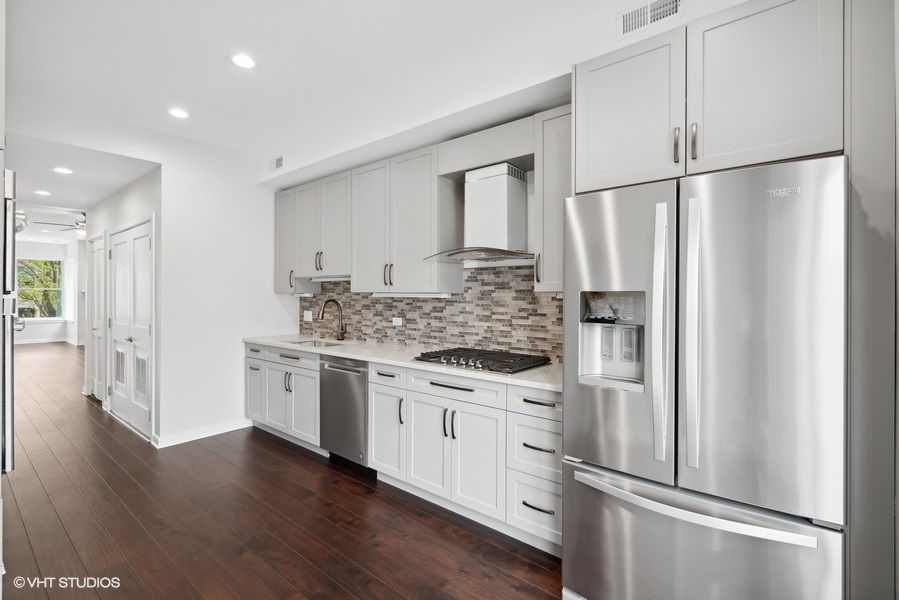 1220 West Roscoe Street Chicago, IL 60657 - Photo 29 of 35 a kitchen with stainless steel appliances granite countertop a refrigerator sink and white cabinets