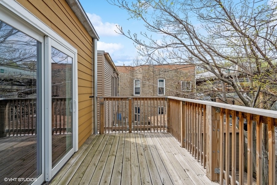 1220 West Roscoe Street Chicago, IL 60657 - Photo 30 of 35 a view of a wooden balcony with wooden floor and fence