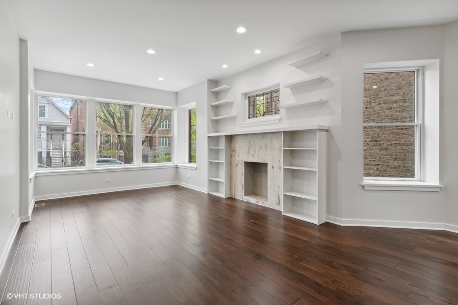 1220 West Roscoe Street Chicago, IL 60657 - Photo 3 of 35 a view of an empty room with wooden floor and a window