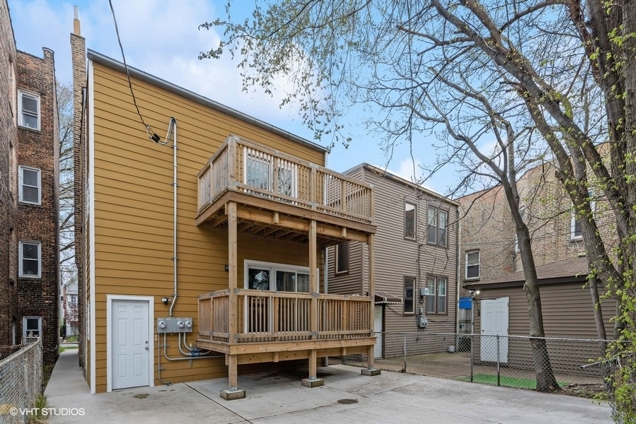 1220 West Roscoe Street Chicago, IL 60657 - Photo 31 of 35 a wooden house with a large window and bench in front of house