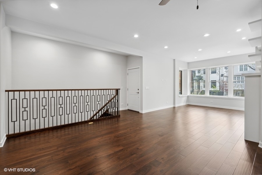 1220 West Roscoe Street Chicago, IL 60657 - Photo 4 of 35 a view of an empty room with wooden floor and windows