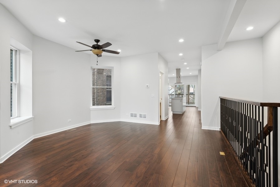 1220 West Roscoe Street Chicago, IL 60657 - Photo 5 of 35 a view of empty room with wooden floor and ceiling fan