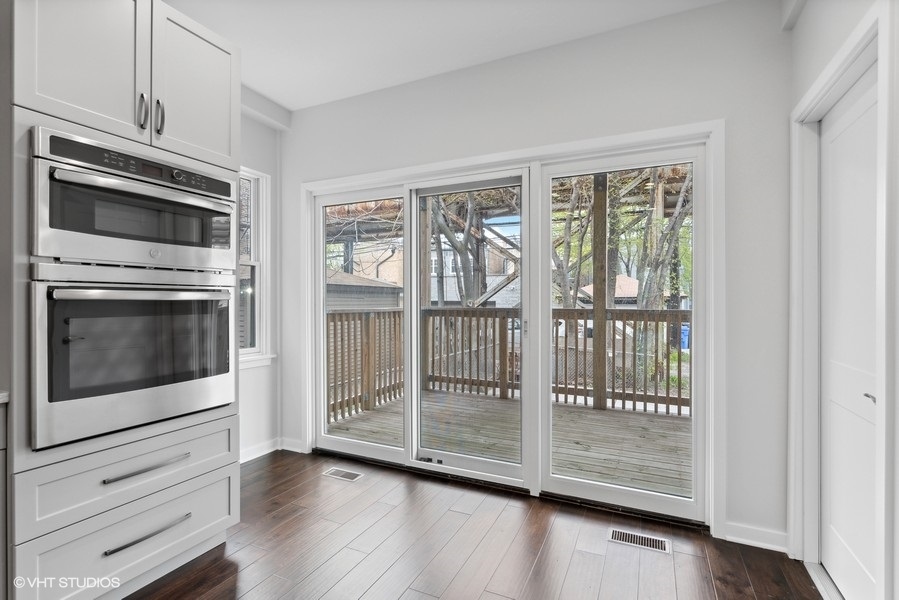 1220 West Roscoe Street Chicago, IL 60657 - Photo 9 of 35 a view of a kitchen with wooden floor and stainless steel appliances