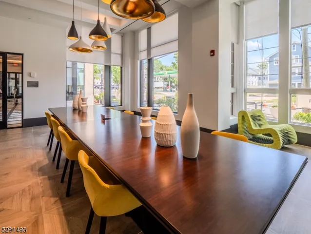 a dining room with wooden floor and windows