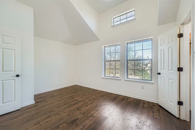 an empty room with wooden floor and mirror