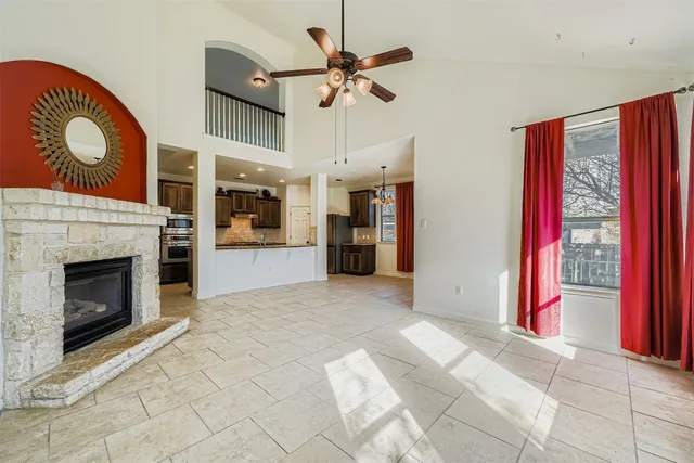 a view of a livingroom with a fireplace and a chandelier fan