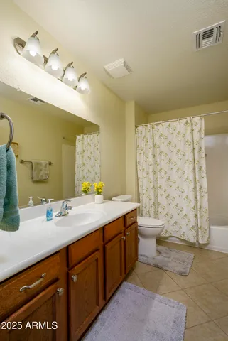 a bathroom with a granite countertop sink a toilet and a mirror