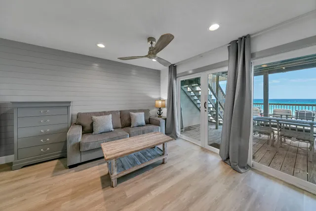 a living room with furniture a flat screen tv and a floor to ceiling window
