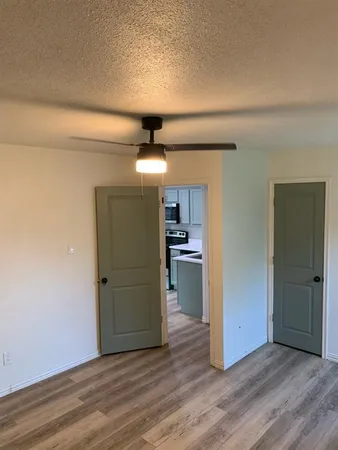a view of a kitchen with a refrigerator and wooden floor