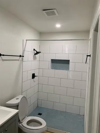 a bathroom with a toilet and a shower