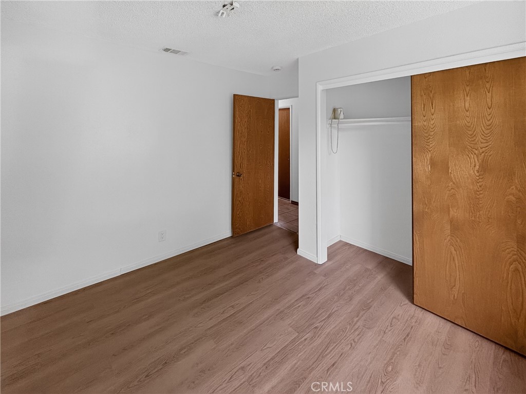 7451 Diamond Street Riverside, CA 92504 - Photo 15 of 31 a view of an empty room with wooden floor and closet
