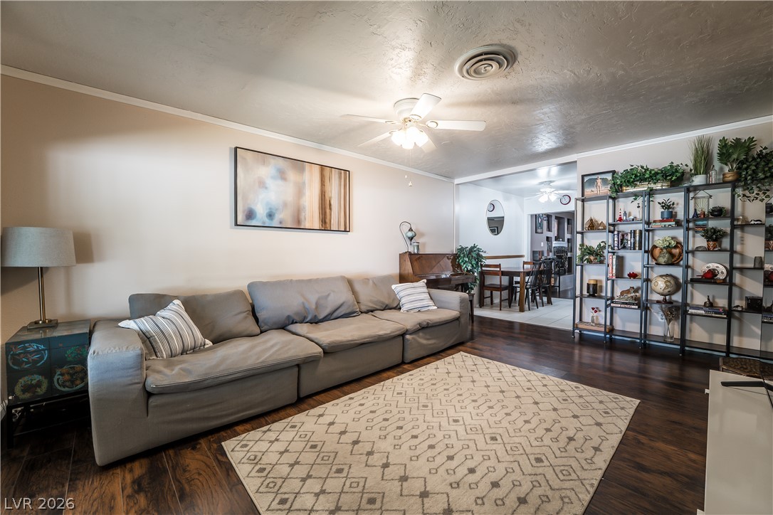 1324 Appaloosa Road Boulder City, NV 89005 - Photo 2 of 42 A generous living area featuring rich hardwood floors flows into an adjacent dining space, perfect for entertaining.