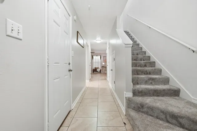 a view of a hallway with white walls and a window