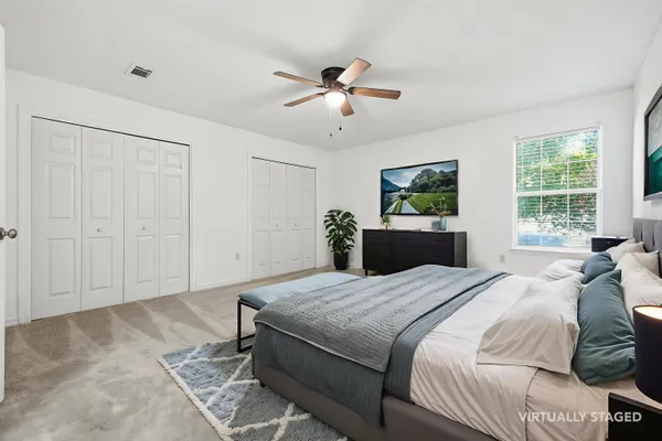 a bedroom with a large bed and a chandelier