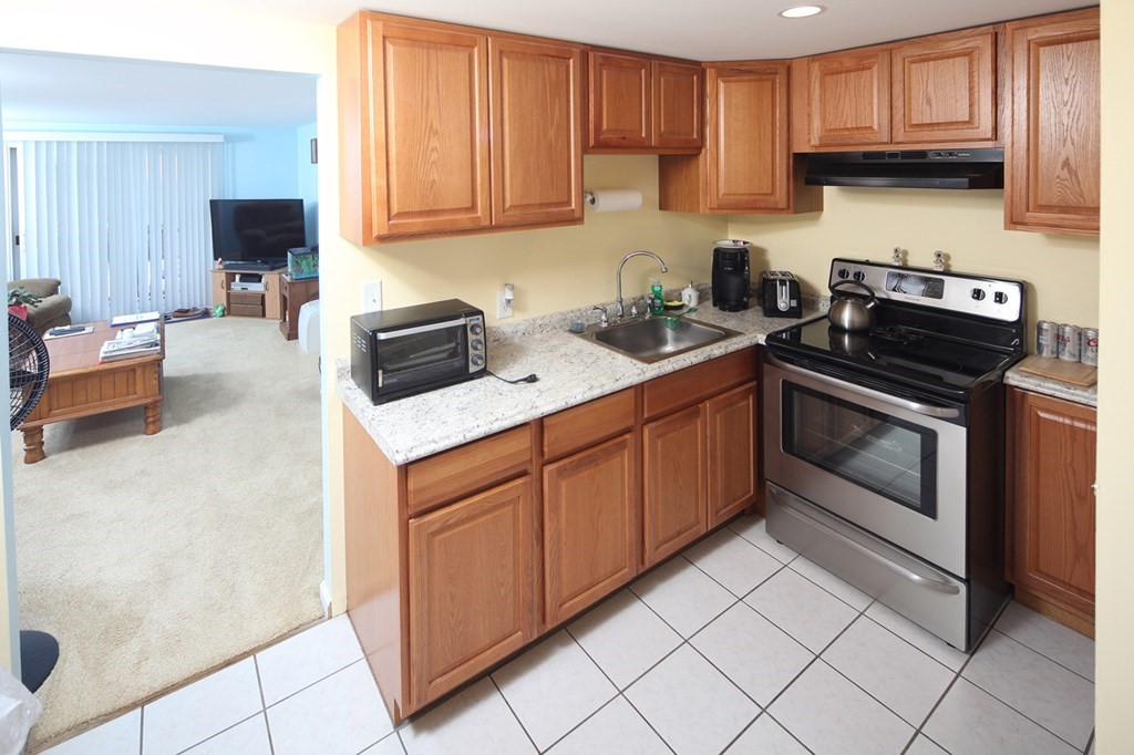 2 Tideview Path, Unit 9 Plymouth, MA 02360 - Photo 3 of 9 a kitchen with stainless steel appliances granite countertop a stove a sink and a white cabinets