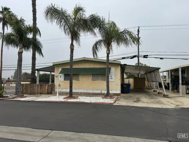 a view of a swimming pool with a lawn chairs under palm trees