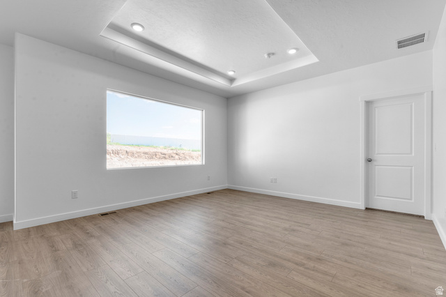 1338 West 2350 South, Unit 19 Perry, UT 84302 - Photo 12 of 14 Spacious room featuring wood-finish flooring, a tray ceiling with recessed lighting, and a large horizontal window
