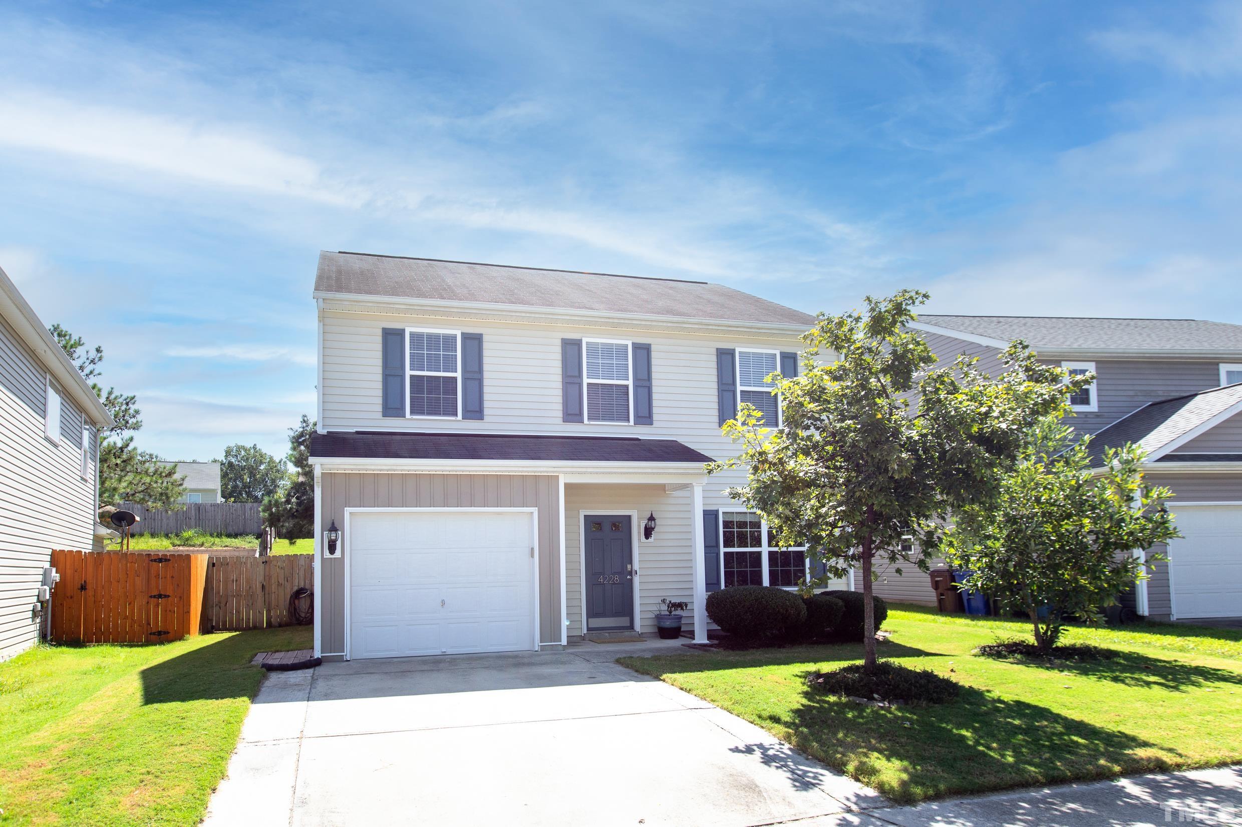 4228 Amber Stone Way Durham, NC 27704 - Photo 2 of 34 a front view of a house with a yard and garage