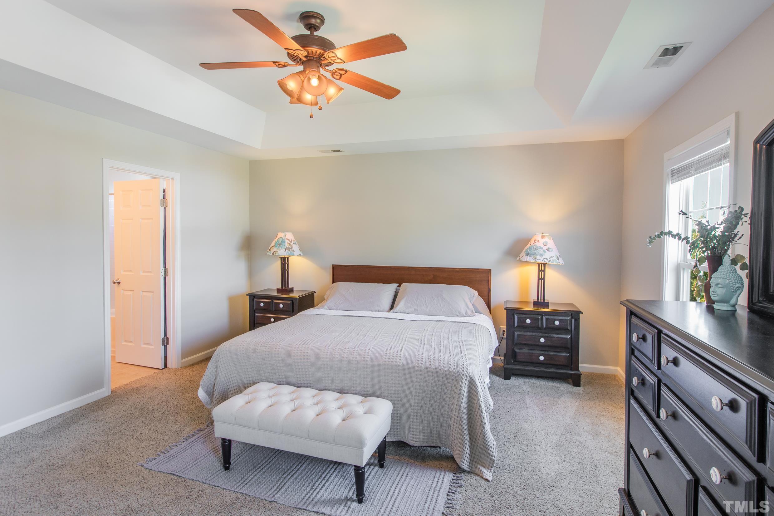 4228 Amber Stone Way Durham, NC 27704 - Photo 28 of 34 a bedroom with a bed and a chandelier